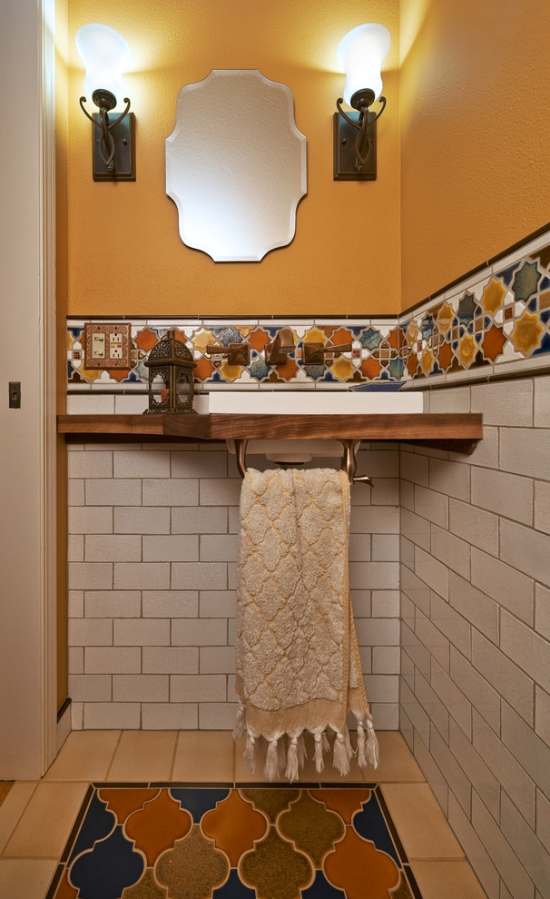 Inspiration for a cloakroom in Portland with a vessel sink, medium wood cabinets, wooden worktops, a one-piece toilet, multi-coloured tiles and metro tiles.