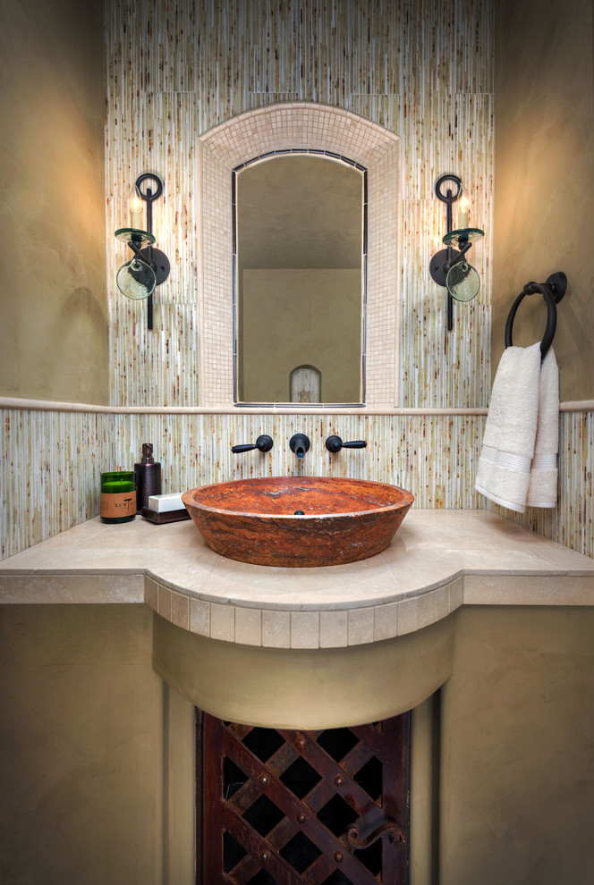 Imagen de aseo mediterráneo pequeño con paredes beige, lavabo sobreencimera, encimera de travertino, baldosas y/o azulejos multicolor y losas de piedra