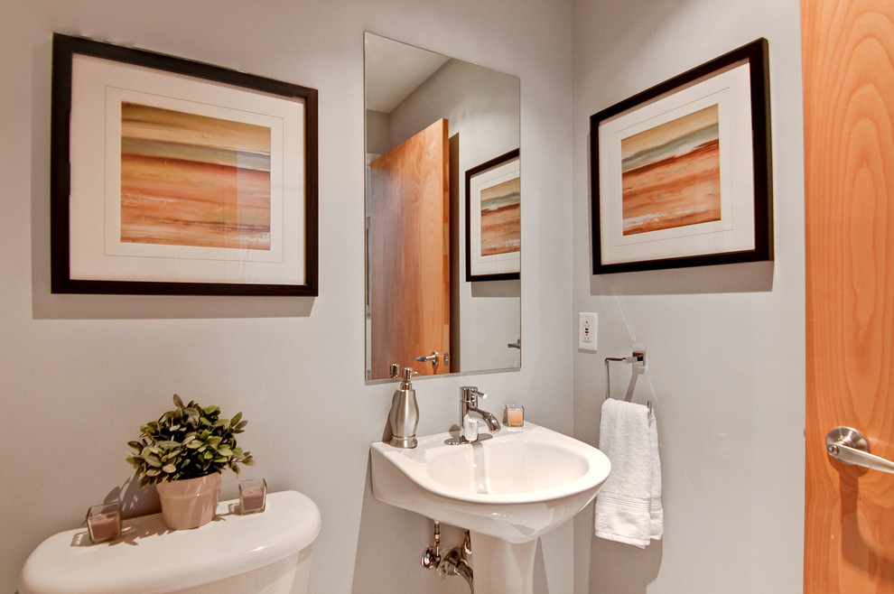 モントリオールにある小さなインダストリアルスタイルのおしゃれなトイレ・洗面所 (ペデスタルシンク、分離型トイレ、白い壁、磁器タイルの床) の写真