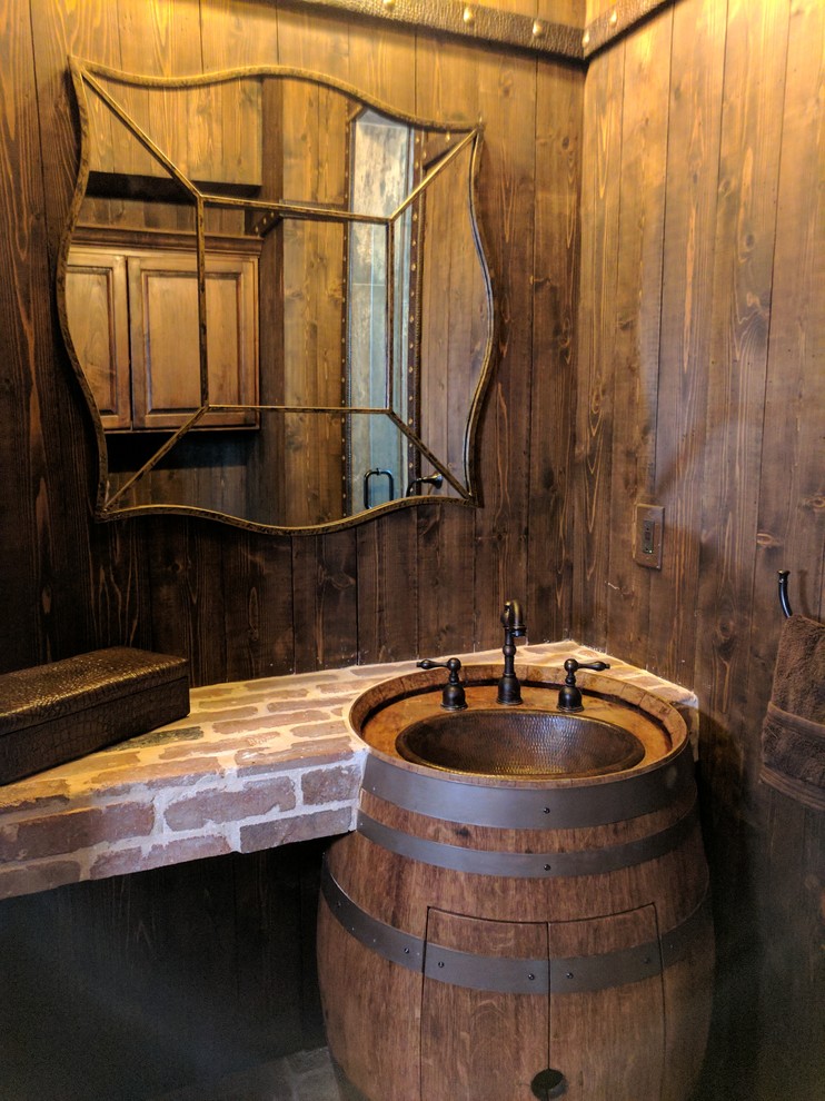 This is an example of a small rustic cloakroom in Austin with raised-panel cabinets, medium wood cabinets, a one-piece toilet, brown walls, brick flooring, an integrated sink and red floors.