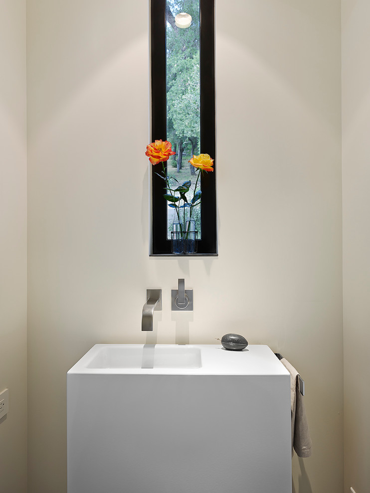 Bild på ett funkis toalett, med vita väggar och ett integrerad handfat