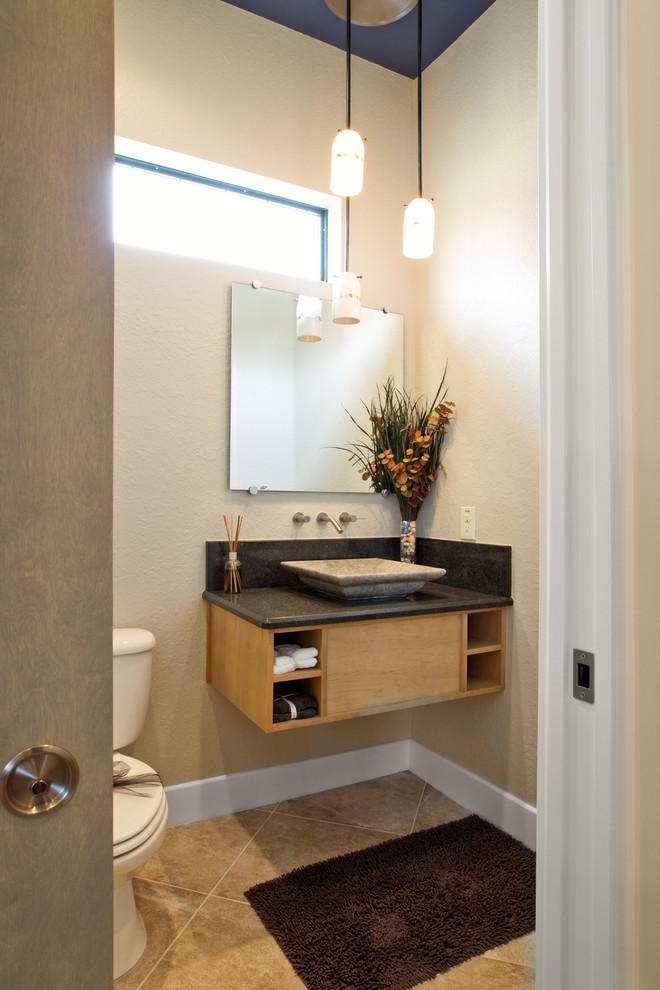 Réalisation d'un petit WC et toilettes design en bois clair avec un placard à porte plane, WC séparés, un mur beige, un sol en travertin, une vasque, un plan de toilette en granite et un sol beige.