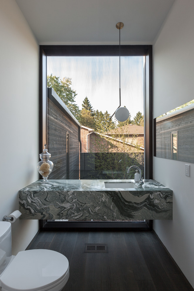 Kleine Moderne Gästetoilette mit Wandtoilette mit Spülkasten, weißer Wandfarbe, dunklem Holzboden, Unterbauwaschbecken und bunter Waschtischplatte in Toronto