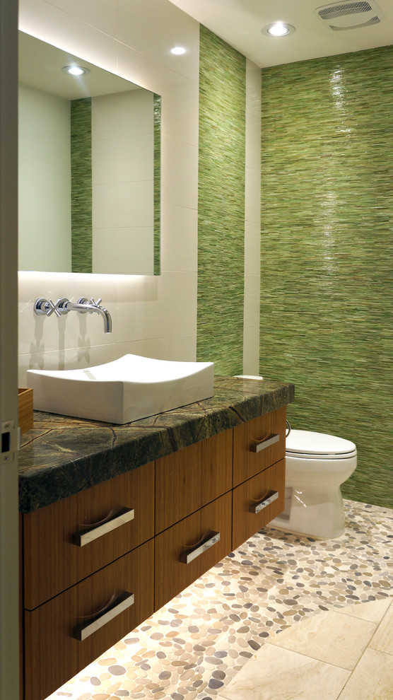 Inspiration för små moderna grått toaletter, med ett fristående handfat, släta luckor, skåp i mellenmörkt trä, granitbänkskiva, en toalettstol med separat cisternkåpa, vit kakel, grön kakel, porslinskakel, gröna väggar, klinkergolv i porslin och beiget golv