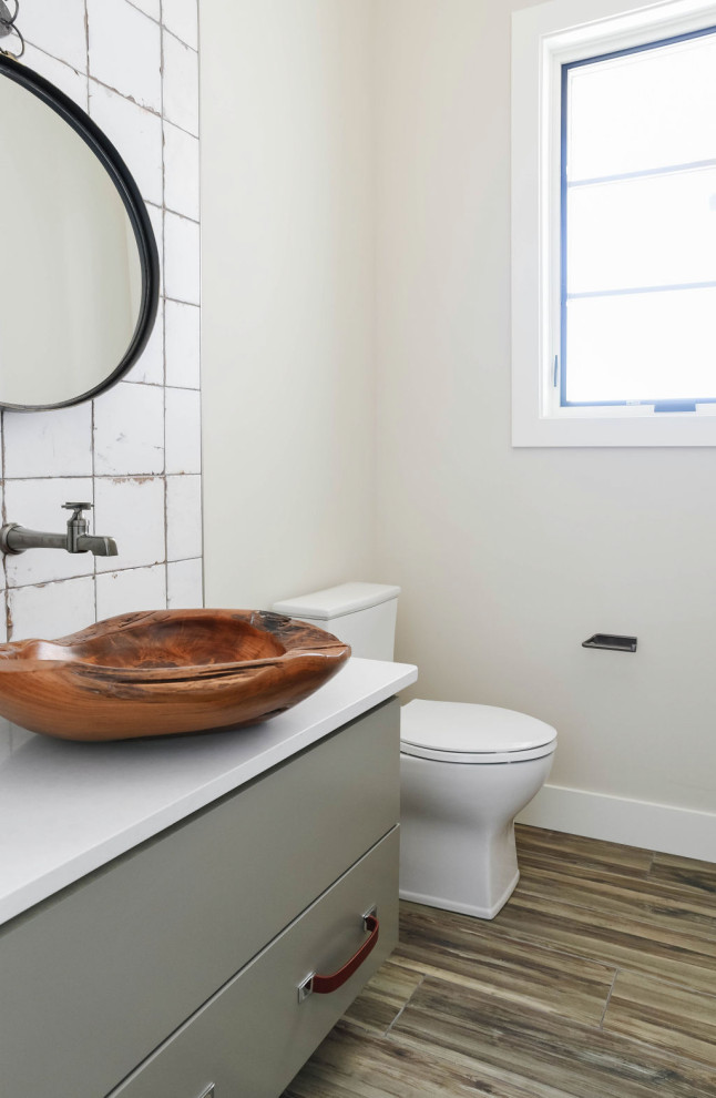 Inspiration for a modern powder room remodel in Omaha with flat-panel cabinets, a two-piece toilet, a vessel sink, quartz countertops and a floating vanity