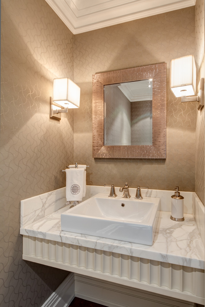 На фото: туалет: освещение в классическом стиле с настольной раковиной и мраморной столешницей с