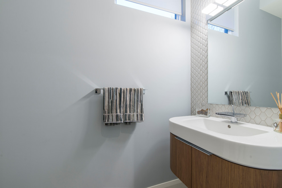 Idéer för små funkis toaletter, med släta luckor, skåp i mellenmörkt trä, vit kakel, porslinskakel, grå väggar och ett integrerad handfat