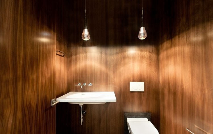 Inspiration för ett litet funkis toalett, med släta luckor, skåp i mellenmörkt trä, en vägghängd toalettstol, bruna väggar, betonggolv, ett väggmonterat handfat och beiget golv