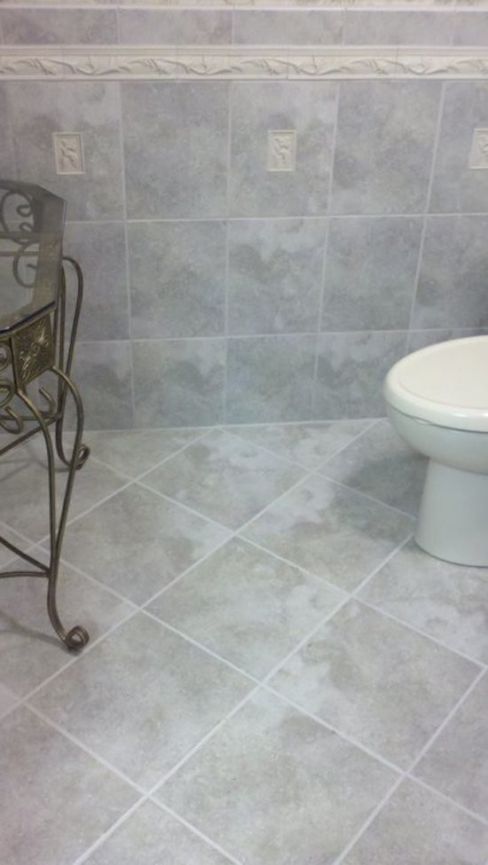 Inspiration pour un WC et toilettes traditionnel de taille moyenne avec WC à poser, un carrelage gris, des carreaux de céramique, un mur multicolore et un sol en carrelage de céramique.