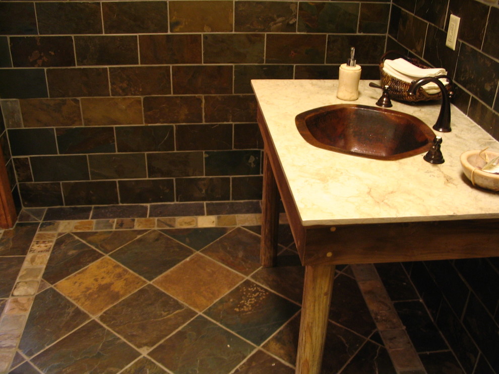 Cette image montre un WC et toilettes chalet de taille moyenne avec du carrelage en ardoise, un mur multicolore, un sol en ardoise, un lavabo posé et un sol multicolore.