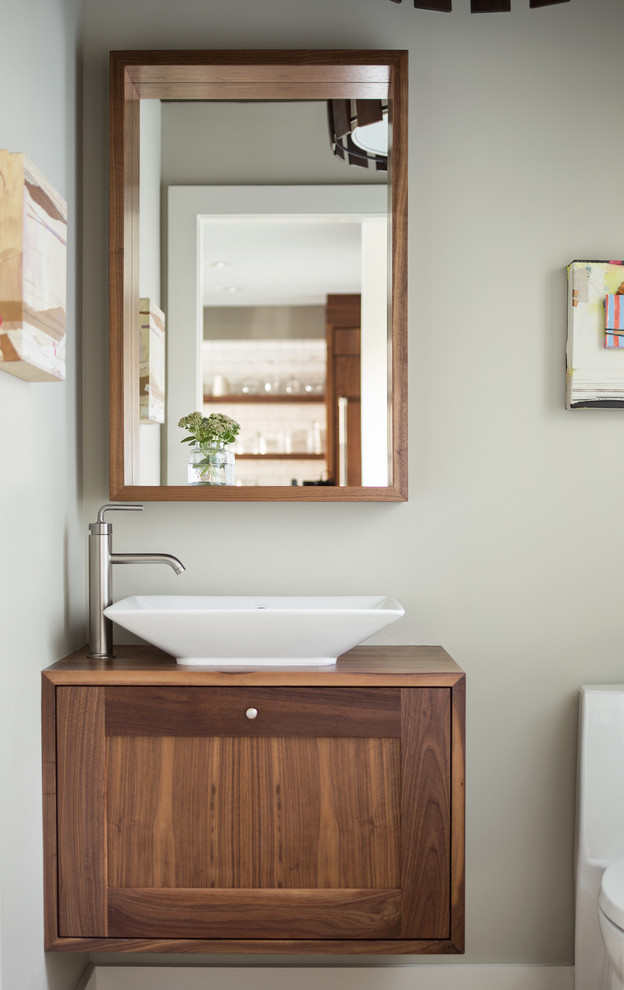 Esempio di un bagno di servizio tradizionale con lavabo a bacinella, ante in stile shaker, ante in legno bruno, top in legno e pareti grigie