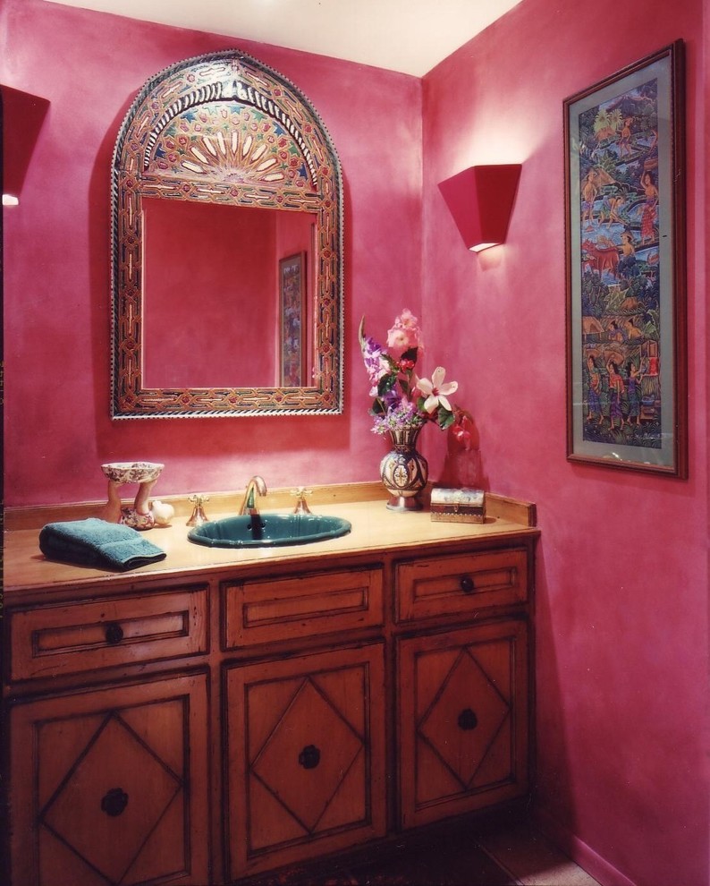 Réalisation d'un petit WC et toilettes bohème en bois foncé avec un lavabo posé, un placard avec porte à panneau surélevé, un plan de toilette en bois, WC séparés, un sol en bois brun et un mur rose.