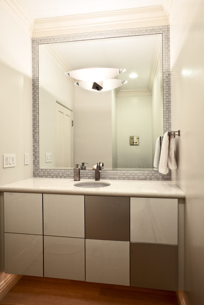 Réalisation d'un WC et toilettes design de taille moyenne avec un lavabo encastré, un placard à porte plane et un mur blanc.
