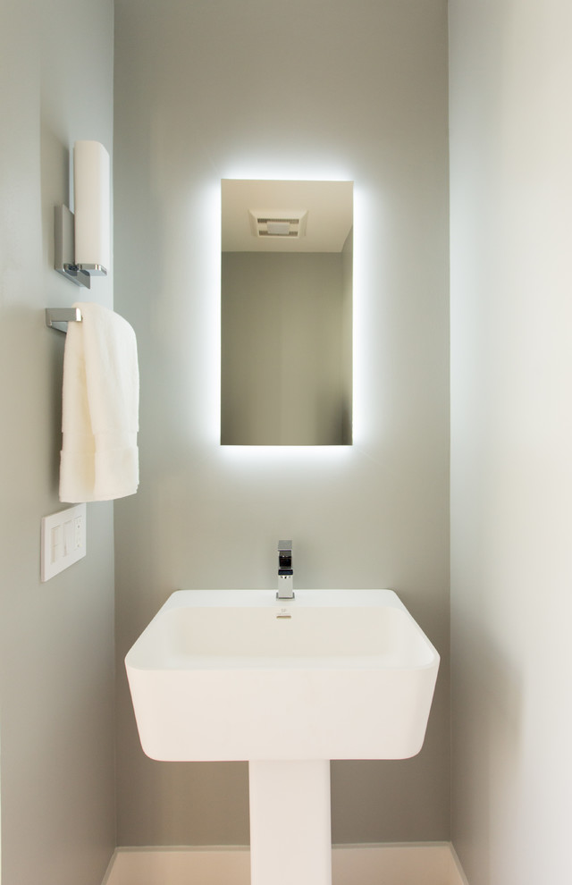 Foto på ett litet funkis toalett, med grå väggar, ljust trägolv, ett piedestal handfat och en toalettstol med hel cisternkåpa