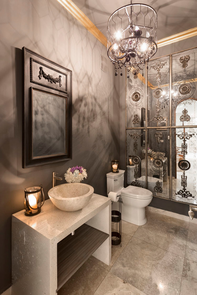 На фото: туалет в средиземноморском стиле с унитазом-моноблоком, серыми стенами, настольной раковиной, серым полом и серой столешницей