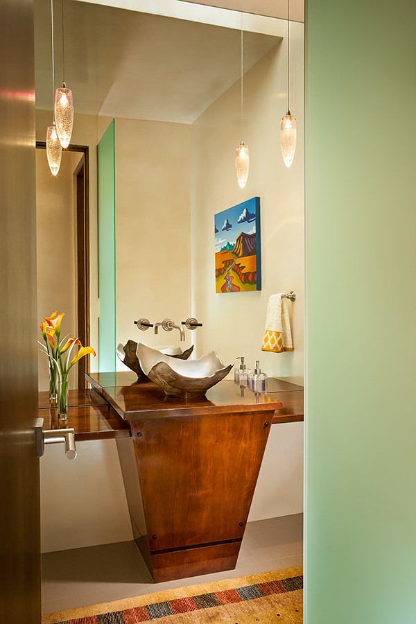 アルバカーキにある高級な中くらいなサンタフェスタイルのおしゃれなトイレ・洗面所 (白い壁、セラミックタイルの床、ベッセル式洗面器、木製洗面台、ブラウンの洗面カウンター) の写真