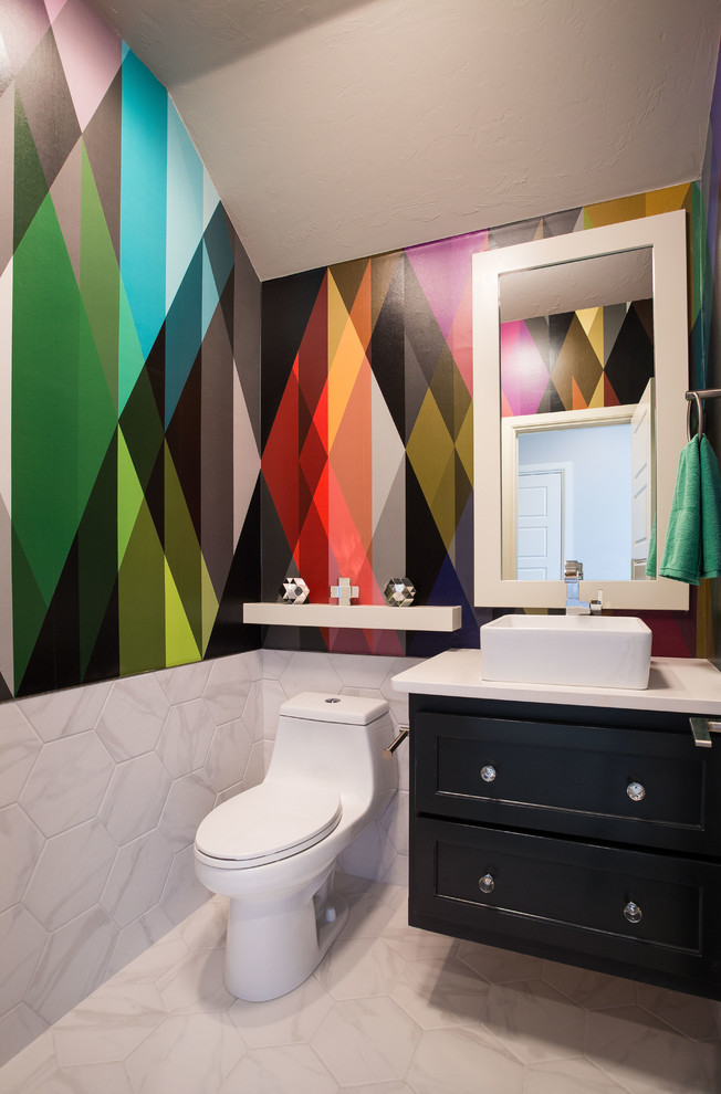 Transitional white tile white floor powder room photo in Oklahoma City with recessed-panel cabinets, black cabinets, a one-piece toilet, multicolored walls, a vessel sink and white countertops