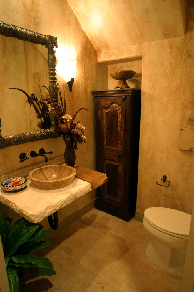 Mittelgroße Urige Gästetoilette mit Wandtoilette mit Spülkasten, beiger Wandfarbe, Travertin, Aufsatzwaschbecken und Kalkstein-Waschbecken/Waschtisch in Austin