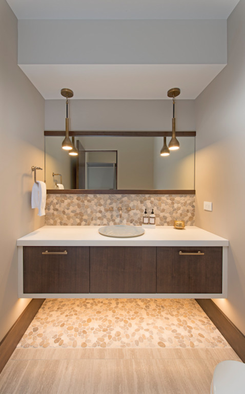 Exemple d'un WC et toilettes tendance avec un placard à porte plane, un sol en carrelage de porcelaine et un plan de toilette en surface solide.