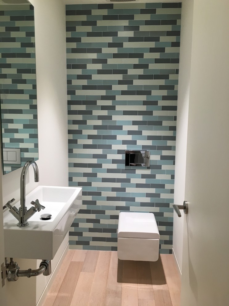 Aménagement d'un petit WC suspendu moderne avec un carrelage bleu, un lavabo suspendu, des carreaux de céramique et parquet clair.