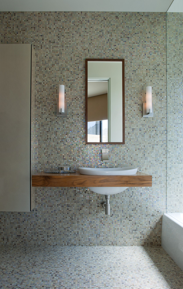 Moderne Gästetoilette mit Einbauwaschbecken, Waschtisch aus Holz, farbigen Fliesen, Mosaikfliesen, bunten Wänden, Mosaik-Bodenfliesen und brauner Waschtischplatte in Phoenix