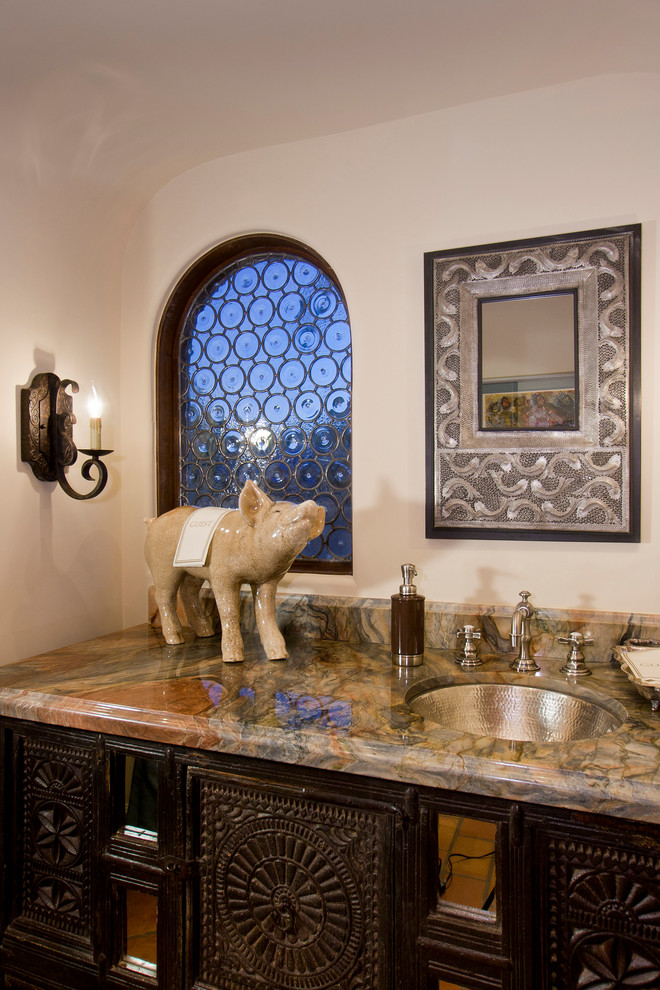 Photo of a mediterranean cloakroom in Phoenix with dark wood cabinets.