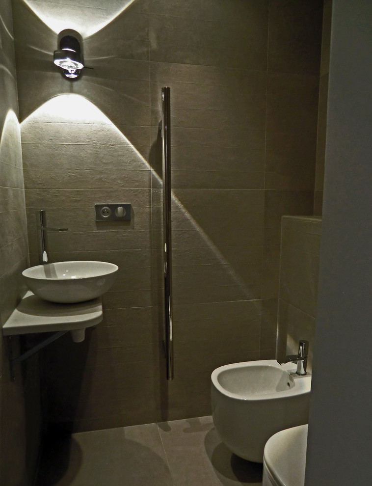 Immagine di un bagno di servizio minimalista con lavabo a bacinella, top in quarzo composito, piastrelle grigie e piastrelle in ceramica