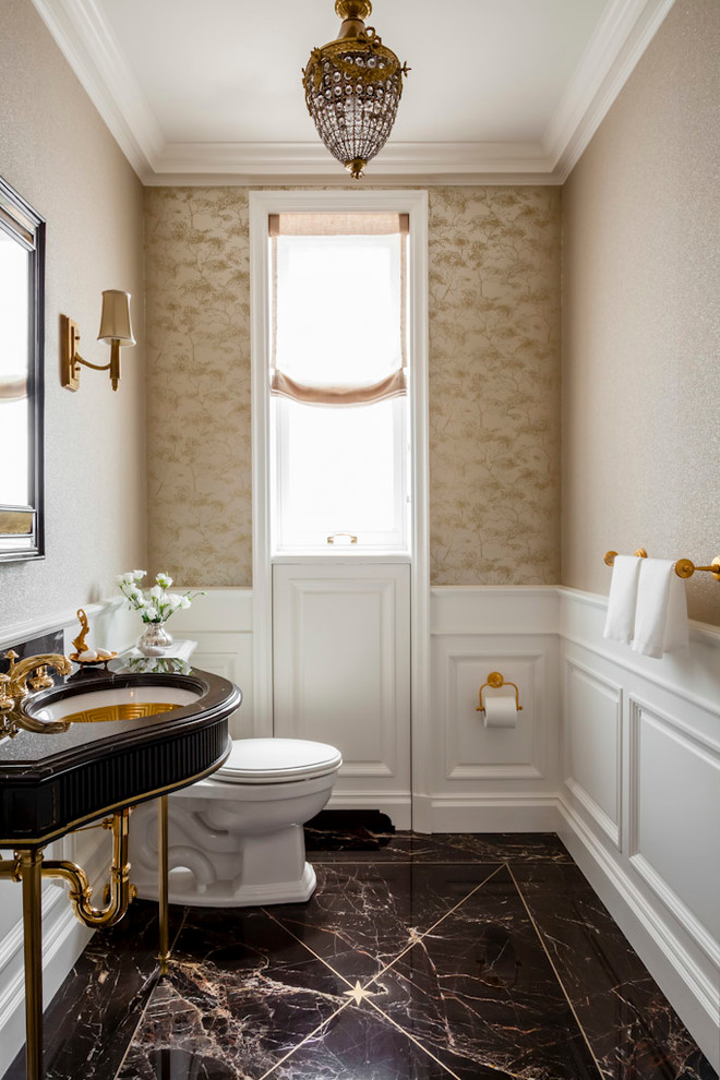Inspiration for a medium sized traditional cloakroom in New York with freestanding cabinets, a two-piece toilet, beige walls and a console sink.