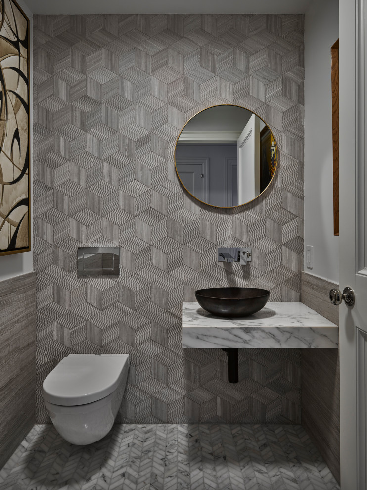 Medium sized contemporary cloakroom in New York with a wall mounted toilet, grey tiles, white walls, marble flooring, a vessel sink, marble worktops, grey floors and grey worktops.