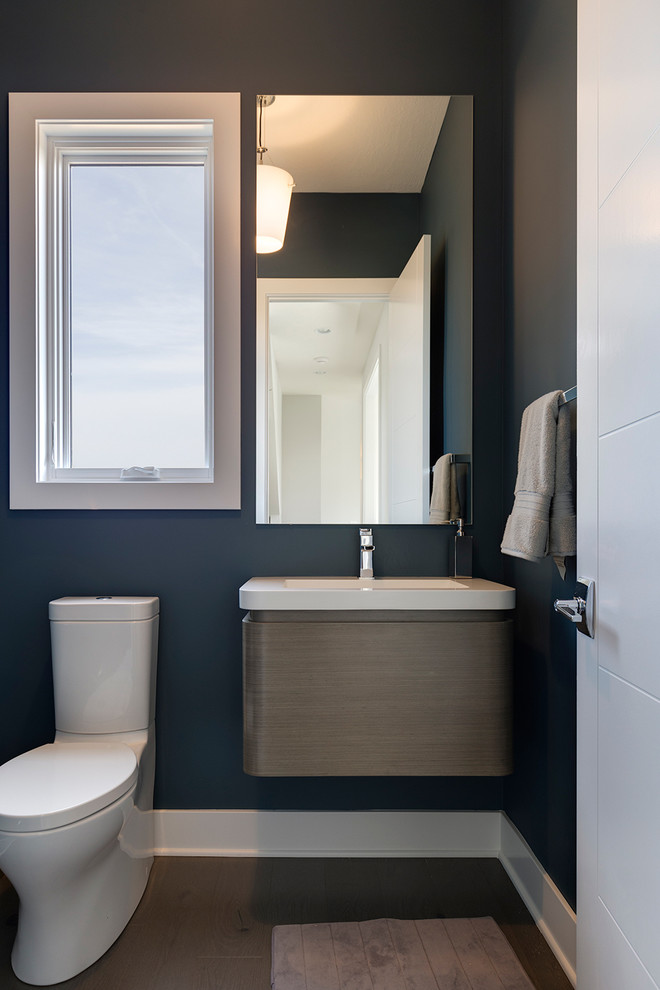 Idee per un piccolo bagno di servizio moderno con ante in legno scuro, pareti blu, parquet scuro e lavabo integrato