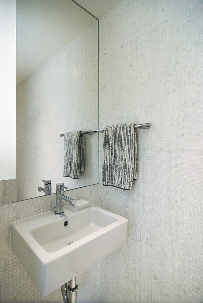 Bild på ett litet funkis toalett, med vit kakel, stenkakel, marmorgolv och ett väggmonterat handfat