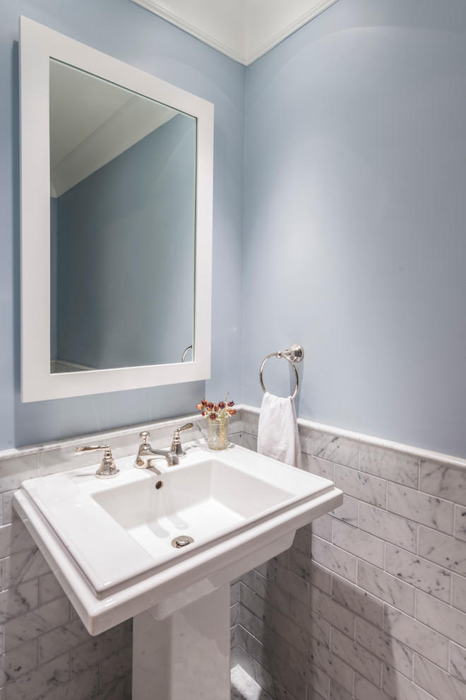 Inredning av ett klassiskt litet toalett, med grå kakel, tunnelbanekakel, blå väggar, marmorgolv och ett piedestal handfat