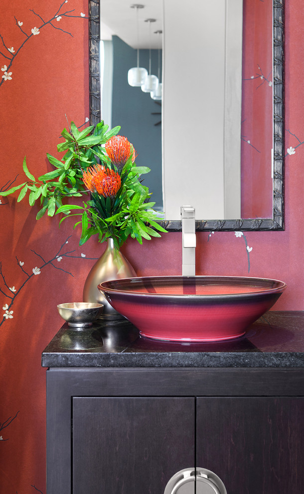 ニューヨークにある小さなコンテンポラリースタイルのおしゃれなトイレ・洗面所 (フラットパネル扉のキャビネット、濃色木目調キャビネット、赤い壁、ベッセル式洗面器、御影石の洗面台) の写真