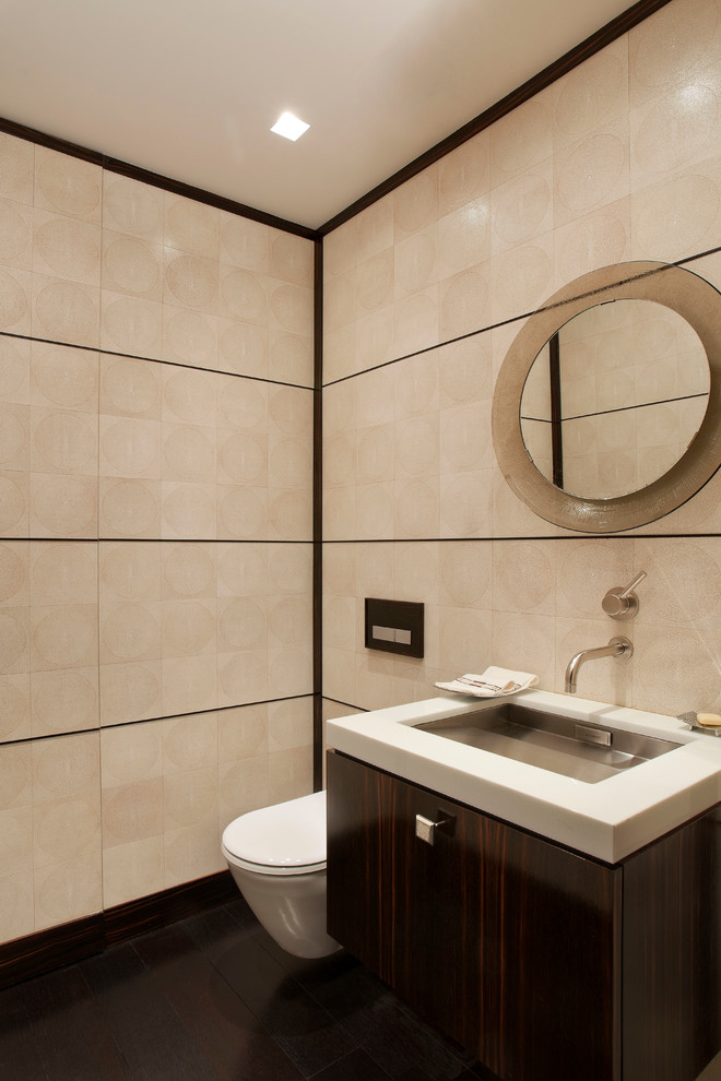 Immagine di un bagno di servizio minimal di medie dimensioni con ante lisce, ante in legno bruno, pareti beige, WC sospeso, piastrelle beige, parquet scuro, lavabo sottopiano e top bianco