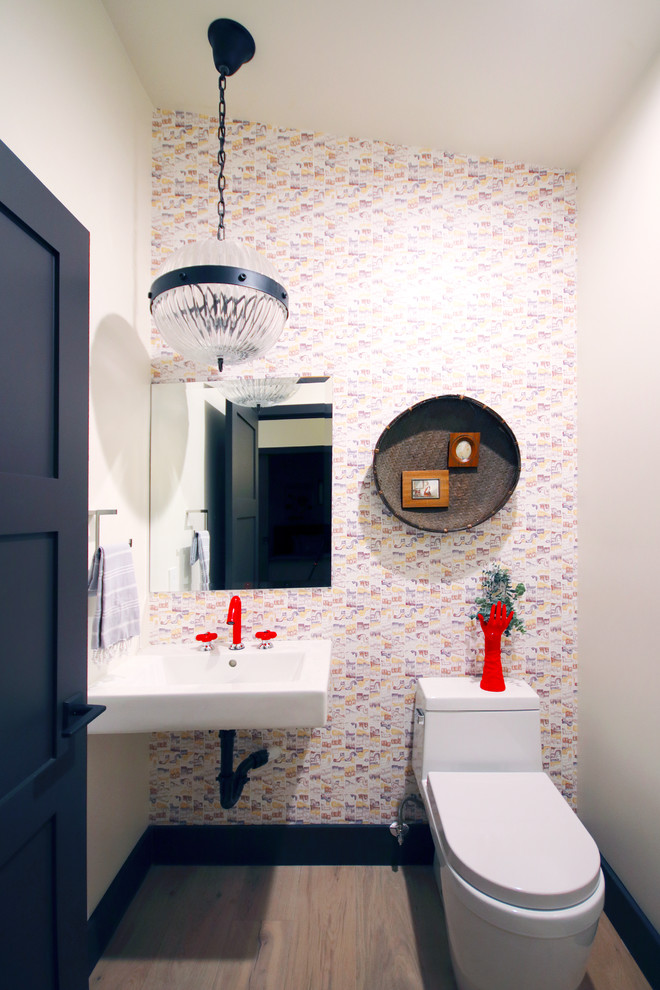 Exemple d'un WC et toilettes éclectique de taille moyenne avec WC séparés, un mur blanc, parquet clair, un lavabo suspendu et un sol gris.