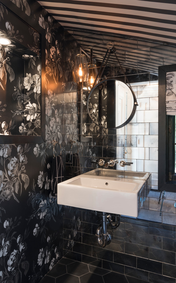Idée de décoration pour un WC et toilettes design avec un mur noir, un lavabo suspendu et un sol noir.