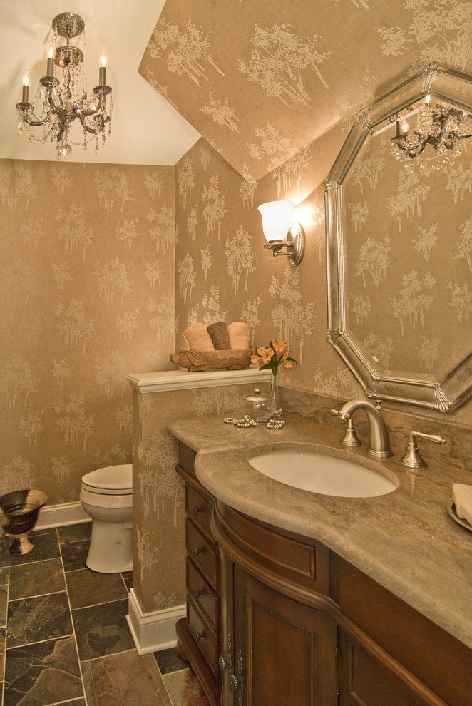 Foto di un bagno di servizio mediterraneo di medie dimensioni con consolle stile comò, ante in legno scuro, piastrelle marroni, pareti beige e lavabo sottopiano