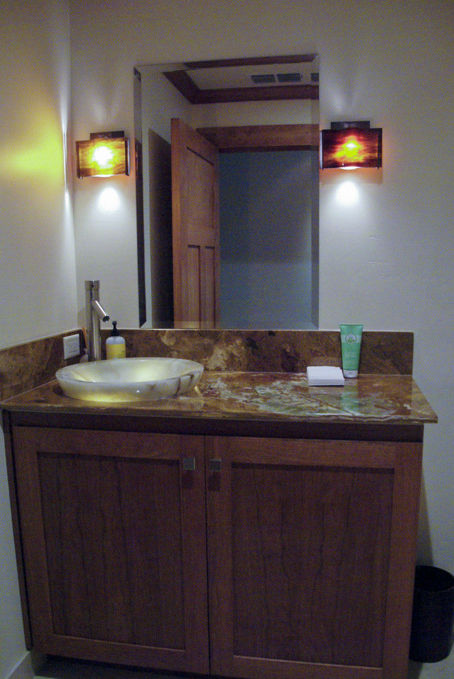 Inspiration pour un petit WC et toilettes craftsman en bois brun avec un placard avec porte à panneau encastré, un plan de toilette en granite, WC à poser, un mur blanc et un sol en carrelage de céramique.