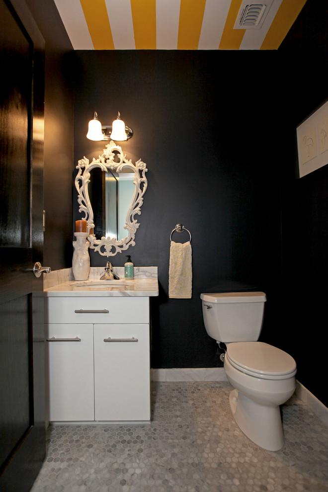 Example of a mid-sized eclectic mosaic tile floor and white floor powder room design in New York with flat-panel cabinets, white cabinets, a two-piece toilet, black walls, an undermount sink, marble countertops and white countertops