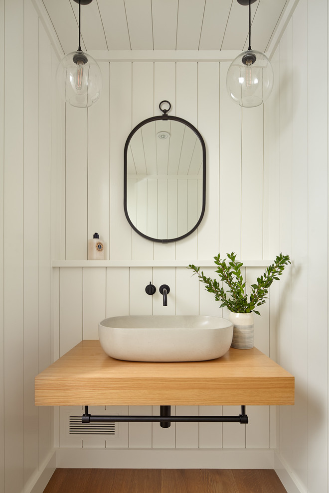 Idee per un bagno di servizio chic con pareti bianche, pavimento in legno massello medio, lavabo a bacinella e top in legno