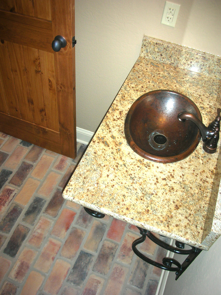 Foto på ett mellanstort medelhavsstil toalett, med bruna väggar, tegelgolv, ett piedestal handfat och flerfärgat golv