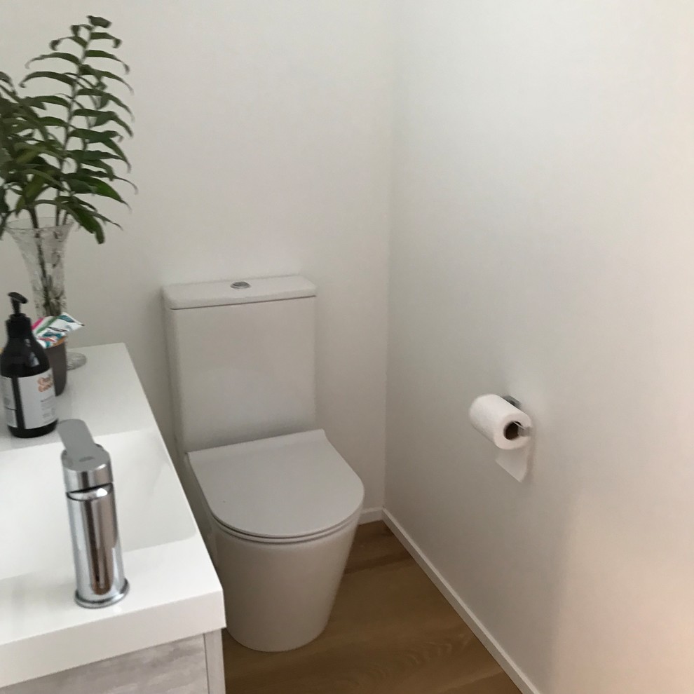 Photo of a contemporary cloakroom in Other with white walls and light hardwood flooring.