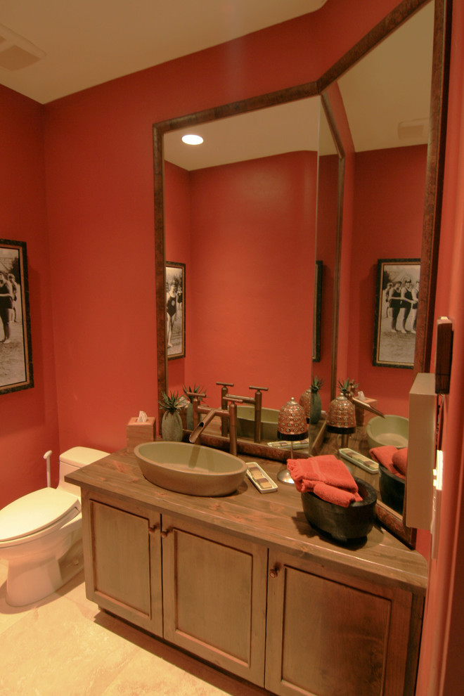 Ispirazione per un bagno di servizio bohémian con lavabo a bacinella, ante con riquadro incassato, ante in legno scuro, top in legno, WC monopezzo e pareti rosse