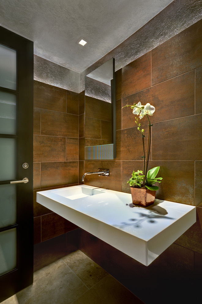 Стильный дизайн: туалет в современном стиле с монолитной раковиной, белой столешницей и разноцветной плиткой - последний тренд
