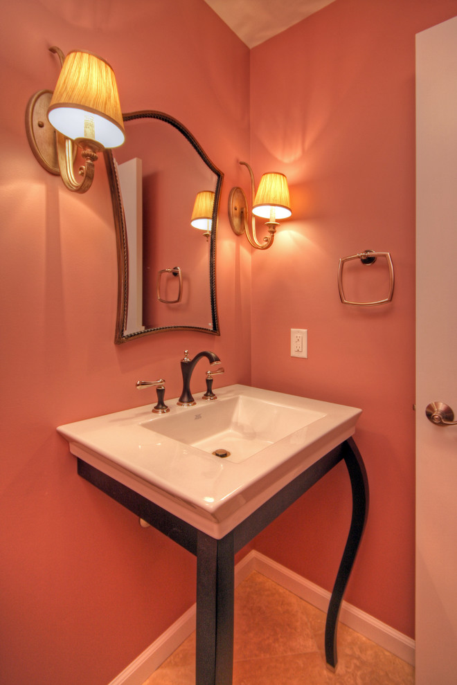 Modelo de aseo bohemio pequeño con lavabo sobreencimera, puertas de armario de madera en tonos medios, sanitario de dos piezas, paredes rosas, suelo de mármol y suelo beige