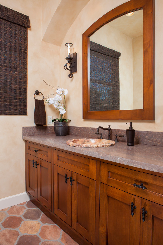 Inspiration for a medium sized traditional cloakroom in San Diego with medium wood cabinets, a two-piece toilet, multi-coloured tiles, beige walls, a built-in sink, granite worktops and beaded cabinets.