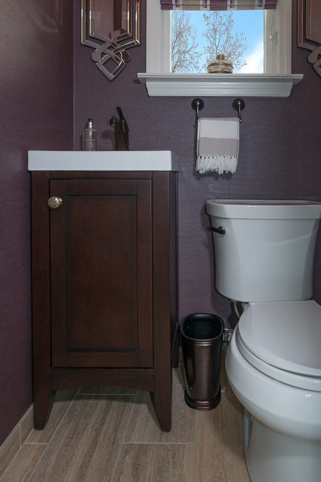 Foto di un piccolo bagno di servizio tradizionale con ante in stile shaker, ante in legno bruno, WC a due pezzi, pareti viola, pavimento in gres porcellanato, lavabo sottopiano, top in superficie solida, pavimento marrone e top bianco