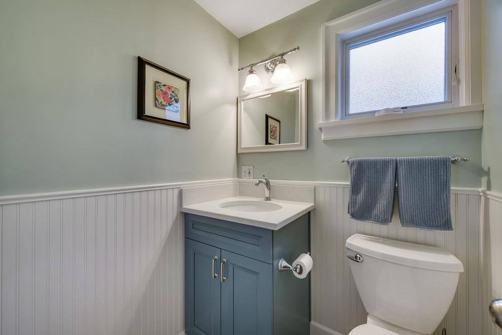 Idées déco pour un WC et toilettes classique de taille moyenne avec un placard à porte shaker, des portes de placard bleues, WC séparés, un mur bleu, un sol en carrelage de porcelaine, un lavabo encastré, un plan de toilette en quartz modifié, un sol noir et un plan de toilette blanc.