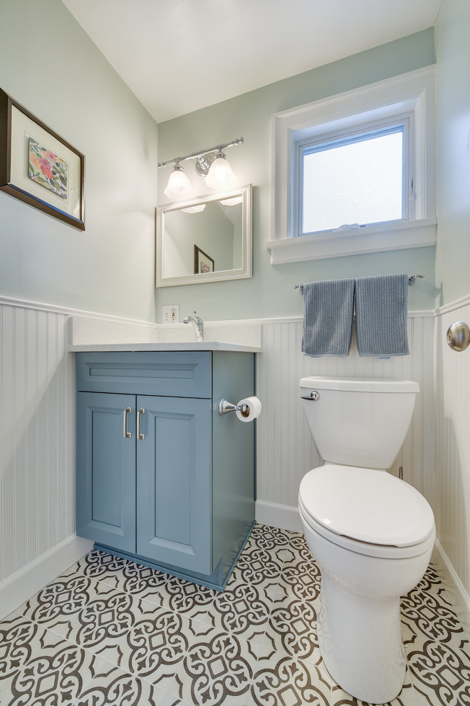 Inspiration pour un WC et toilettes traditionnel de taille moyenne avec un placard à porte shaker, des portes de placard bleues, WC séparés, un mur bleu, un sol en carrelage de porcelaine, un lavabo encastré, un plan de toilette en quartz modifié, un sol noir et un plan de toilette blanc.
