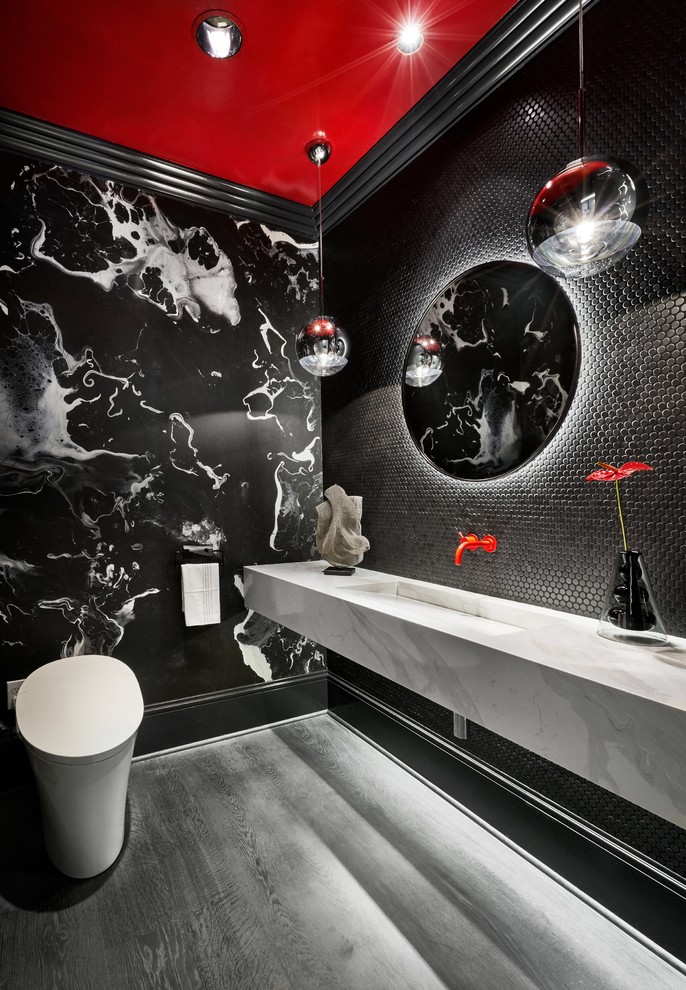 На фото: туалет в современном стиле с инсталляцией, черной плиткой, плиткой мозаикой, черными стенами, монолитной раковиной, серым полом и белой столешницей с